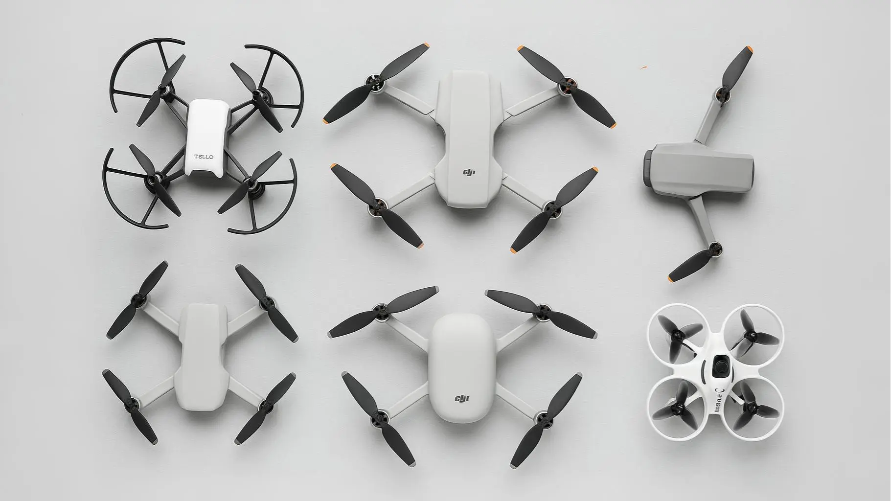 A top view of the best drones for beginners including Ryze Tello, DJI Mini 3, DJI Flip, Potensic Atom SE, DJI Neo, and BetaFPV Cetus X on a neutral background.